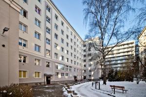 ワルシャワにあるNiepodleglosci Serviced Apartmentsの大きな建物前の雪道