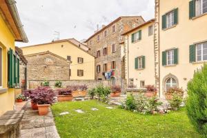 une cour dans un immeuble ancien avec un jardin dans l'établissement Il Giardino di Adele - Together in Tuscany, à Cortone