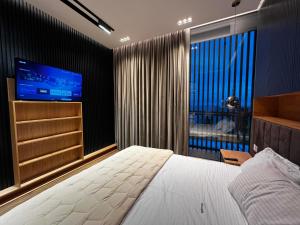 um quarto com uma cama grande e uma televisão em Vila 122B Palase Privat Pool em Himare