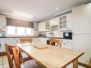 een keuken met een houten tafel en houten stoelen bij Shoreline House in Fraserburgh