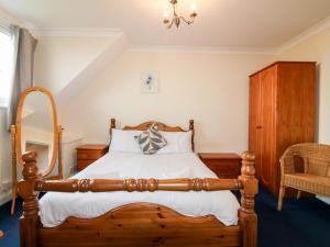 a bedroom with a wooden bed and a chair at Shoreline House in Fraserburgh