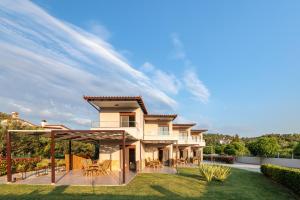 a large house with a deck and patio at Arteon Villas in Agios Nikolaos