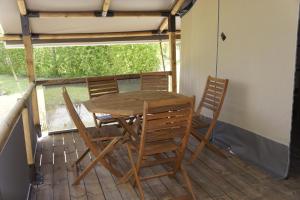 een houten tafel en stoelen op een veranda bij DOMAINE DU MURIER in Die