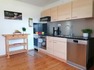 a kitchen with stainless steel appliances and a wooden table at Ferienwohnung Fritz in Sigmarszell