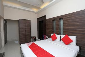 a bedroom with a large bed with red pillows at Hotel O South Fern in Kolkata +40 photos