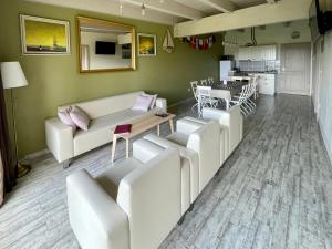 a living room with white couches and a table at Apartmány Modřínový Dům in Horní Planá