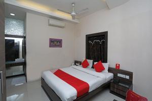 a bedroom with a large bed with red pillows at Hotel South Fern in Ballygunge
