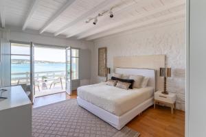 een slaapkamer met een bed en uitzicht op de oceaan bij Ambassador Luxury Villas in Santa Maria