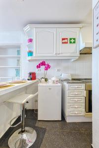 eine Küche mit weißen Schränken und rosa Blumen auf der Theke in der Unterkunft InLoveApartments - Alfama Balcony in Lissabon + 16 Fotos