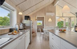 uma cozinha com armários brancos e uma bancada em 4 Bedroom Awesome Home In Millinge em Millinge