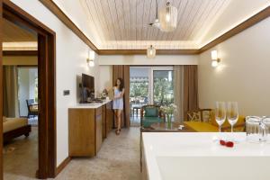 Whistling Woodzs Resort في دانديلي: امرأة تقف في غرفة المعيشة في غرفة الفندق