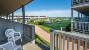 a balcony with chairs and a view of a park at Riviera Beach Resort in South Yarmouth