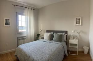 biała sypialnia z łóżkiem i oknem w obiekcie Rooms Pilarica w Madrycie