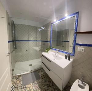 łazienka z prysznicem, umywalką i lustrem w obiekcie Rooms Pilarica w Madrycie