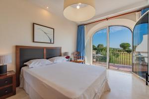 sypialnia z łóżkiem i dużym oknem w obiekcie Arcos Gardens Sol Rent Golf w mieście Arcos de la Frontera