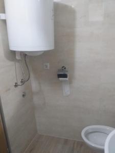a bathroom with a toilet and a toilet paper dispenser at Apartmani Primus in Bosanska Gradiška