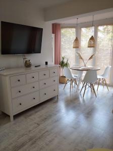 a living room with a white dresser with a tv on it at Apartament w Morskim Stylu in Ustka