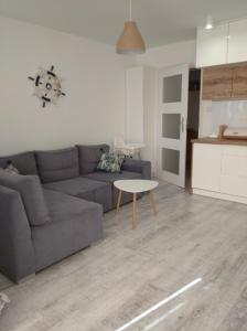 a living room with a couch and a table at Apartament w Morskim Stylu in Ustka