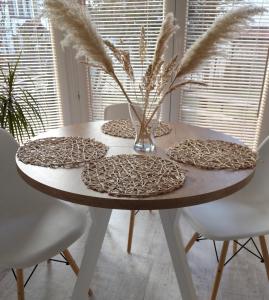 een eettafel met een witte tafel en stoelen bij Apartament w Morskim Stylu in Ustka