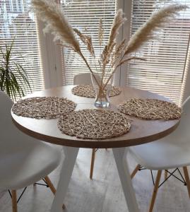 a dining room table with a white table and chairs at Apartament w Morskim Stylu in Ustka +2 photos
