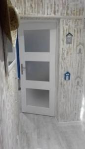 een witte deur in een huis met een muur bij Apartament w Morskim Stylu in Ustka