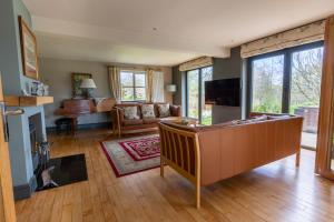 a living room with a couch and a television at Modernised seven bedroom country house and garden with hot tub in Cranbrook