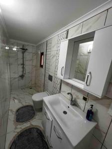 ein weißes Bad mit einem Waschbecken und einem WC in der Unterkunft Doğa içinde şehir merkezinde in Yomra