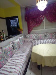 ein Wohnzimmer mit einem Sofa und einem Tisch in der Unterkunft Wad fes hay Molay Driss GH14 in Fès
