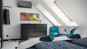 a bedroom with two beds and two blue chairs at Arácsi Apartman 1610 in Balatonfüred