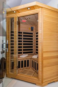 a wooden sauna with a glass door in a bathroom at Arácsi Apartman 1610 in Balatonfüred