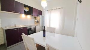 a kitchen with a white counter and purple cabinets at Center Apartment with Terrace and Free Parking in Kaštela
