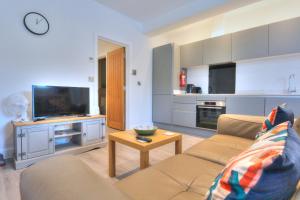 a living room with a couch and a television at Dartmoor View one bedroom Apartment Dog Friendly Close To Town FREE PARKING in Totnes