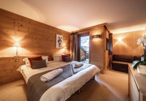 a bedroom with a large bed with wooden walls at Chalet du Samoyède in Morzine