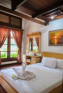 - une chambre avec 2 lits et un bureau avec des fenêtres dans l'établissement Jawa Dwipa Heritage Resort, à Tawangmangu