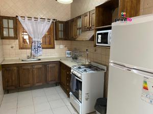 圖努揚的住宿－Una casa amplia y centrica，厨房配有冰箱和炉灶。 顶部烤箱