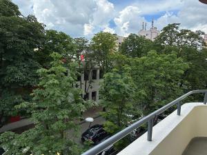 uma vista a partir de uma varanda de um edifício com árvores em Soin Rooms em Tirana