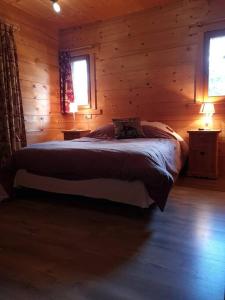 1 dormitorio con 1 cama en una cabaña de madera en Chalet familial - Pyrénées, au cœur des 3 stations, en La Cabanasse