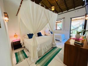a bedroom with a bed with a canopy at Pousada Pandoro in Trancoso