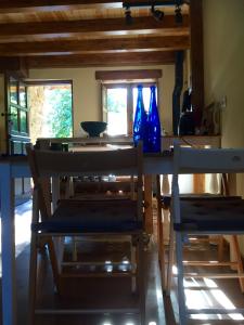 mesa de comedor con 2 sillas y jarrones azules en La Pipa, en Santillán