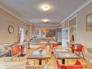 um restaurante com mesas e cadeiras e uma cozinha em @ Home Hotel Locarno em Locarno