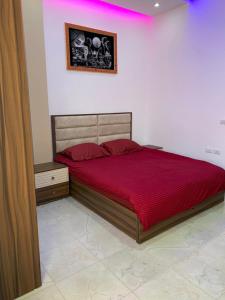 Jasmine Resort & Aqua park في شرم الشيخ: غرفة نوم بسرير كبير مع لحاف احمر