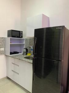 a kitchen with a refrigerator and a microwave at Jasmine Resort & Aqua park in Sharm El Sheikh