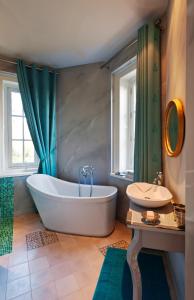 y baño con bañera, lavamanos y bañera. en La Suite Venise au Château de Saint-André, en Mareuil-sur-Lay