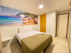 een slaapkamer met een bed met een schilderij aan de muur bij Ed. Crystal Residence in Vila Velha