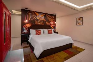 1 dormitorio con 1 cama grande y una pintura en la pared en TRES79 Orizaba Curamoria Collection en Orizaba
