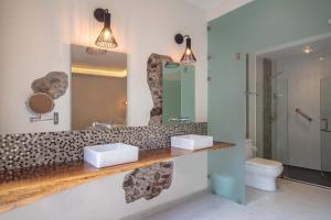 a bathroom with two sinks and a mirror and a toilet at TRES79 Orizaba Curamoria Collection in Orizaba