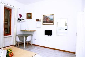 サッサリにあるSogno Allegroの白い部屋(テーブル、椅子2脚、テレビ付)