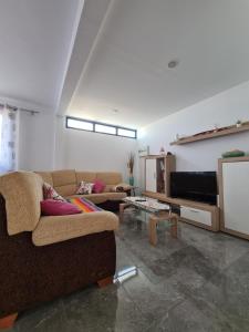 sala de estar con 2 sofás y TV de pantalla plana en Famara San Borondon, en Famara
