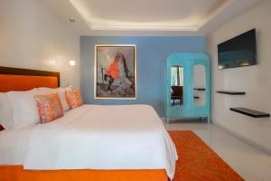 ein Schlafzimmer mit einem weißen Bett und einer blauen Wand in der Unterkunft TRES79 Orizaba Curamoria Collection in Orizaba