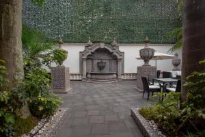 an outdoor patio with a fireplace and tables and chairs at TRES79 Orizaba Curamoria Collection in Orizaba